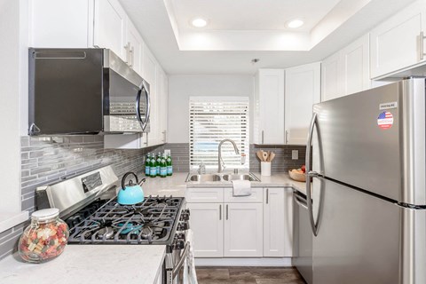 a small kitchen with stainless steel appliances and white cabinets